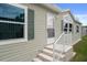 Front door entrance with stone steps, white railing and green shutters at 3818 Chris Dr, Wesley Chapel, FL 33543