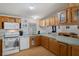 Open kitchen features wood cabinets, laminate countertops, and white appliances at 3818 Chris Dr, Wesley Chapel, FL 33543