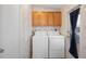 Laundry room featuring a washer, dryer, and wood storage cabinets at 3818 Chris Dr, Wesley Chapel, FL 33543