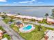 Overhead shot features condos, palm trees and an oddly-shaped pool near the calm water at 3876 Catalina Dr, Bradenton, FL 34210
