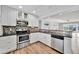 Charming kitchen has stainless steel appliances, granite countertops, and bright white cabinets at 3876 Catalina Dr, Bradenton, FL 34210