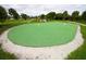 Enjoy a putting green with lush landscaping, palm trees, and a serene setting for practice and recreation at 3876 Catalina Dr, Bradenton, FL 34210