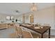 Bright, neutrally decorated dining room with modern chandelier and access to living room at 4096 El Dorado Cv, Bradenton, FL 34210