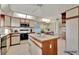 Bright kitchen features an island with tile countertop and appliances at 4096 El Dorado Cv, Bradenton, FL 34210