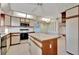 Bright kitchen features an island with tile countertop and appliances at 4096 El Dorado Cv, Bradenton, FL 34210
