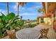 Charming patio featuring a table and lush tropical landscaping, overlooking a serene waterfront view at 4096 El Dorado Cv, Bradenton, FL 34210
