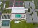 Aerial view of community amenities including tennis and shuffleboard courts, pool and spa, clubhouse and parking at 4153 Fairway Dr, North Port, FL 34287