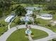 Overhead view of community buildings and pond, surrounded by green space and trees, with a unique circular architectural design at 4153 Fairway Dr, North Port, FL 34287