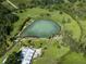 This high angle aerial photograph highlights a natural pond surrounded by lush green space and community recreation areas at 4153 Fairway Dr, North Port, FL 34287