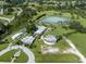 A high angle aerial perspective shows the community features a large pond and unique circular building at 4153 Fairway Dr, North Port, FL 34287