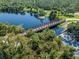Scenic aerial view of a bridge over a peaceful lake, surrounded by lush green trees and vegetation at 4153 Fairway Dr, North Port, FL 34287