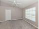 Neutral bedroom with plush carpet, a ceiling fan, and a window letting in natural light at 4153 Fairway Dr, North Port, FL 34287