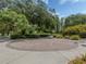 Beautifully landscaped park grounds with a circular brick pattern and green trees at 4153 Fairway Dr, North Port, FL 34287