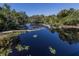 Enjoy the tranquil lake views amidst lush greenery and sunny skies at 4153 Fairway Dr, North Port, FL 34287