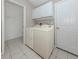 Functional laundry room with a washer, dryer, storage cabinets and tiled flooring at 4153 Fairway Dr, North Port, FL 34287