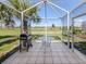 Relaxing screened-in patio with tile flooring and outdoor dining area and a beautiful yard view at 4153 Fairway Dr, North Port, FL 34287