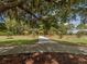 Outdoor playground with a paved walkway, under mature trees, near a recreational area at 4153 Fairway Dr, North Port, FL 34287