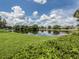Scenic pond view reflecting the sky, framed by lush green lawns and serene landscaping at 4153 Fairway Dr, North Port, FL 34287
