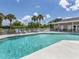 Sparkling community pool with lounge chairs, umbrellas, and nearby pool house for residents' enjoyment at 4153 Fairway Dr, North Port, FL 34287