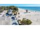 Scenic daytime view of a vibrant beach with white sand, clear blue water, lifeguard tower, and beachgoers enjoying the sun at 4508 Mangrove Point Rd, Bradenton, FL 34210