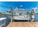 Boat lift shows a boat on a lift with a view of the canal and tropical landscaping at 4508 Mangrove Point Rd, Bradenton, FL 34210