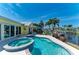 Backyard pool and patio area features an in-ground pool, spa, and tropical landscaping overlooking the canal at 4508 Mangrove Point Rd, Bradenton, FL 34210