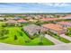 An aerial shot showcasing a residential neighborhood, revealing manicured lawns, vibrant landscaping, and tile roofs at 4524 Baltry Ct, Bradenton, FL 34211