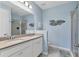 Bathroom with double sinks, light blue walls, glass enclosed shower, and decorative fish at 4524 Baltry Ct, Bradenton, FL 34211
