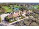 Scenic aerial shot of the clubhouse, surrounded by palm trees, lush landscaping, and serene lake at 4524 Baltry Ct, Bradenton, FL 34211