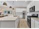 Bright kitchen featuring white cabinets, stainless steel appliances, and a large granite-topped island at 4524 Baltry Ct, Bradenton, FL 34211