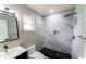 Modern bathroom featuring a stand-up shower with gray marble tiling and black hexagon-shaped flooring at 4616 34Th E Ave, Bradenton, FL 34208