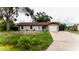 Charming single-story home with stone accents, a well-manicured lawn, and a welcoming turquoise-colored front door at 4616 34Th E Ave, Bradenton, FL 34208
