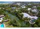 Aerial view of a charming waterfront home nestled along a canal, surrounded by lush greenery and other houses at 4830 Estrada De Costa, Sarasota, FL 34242