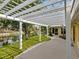 Landscaped backyard with a white pergola overlooking a large pond and lush landscaping at 4830 Estrada De Costa, Sarasota, FL 34242