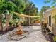 Serene backyard featuring a cozy fire pit area and shade sails, creating an inviting outdoor retreat at 4830 Estrada De Costa, Sarasota, FL 34242