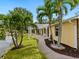 Lush backyard view with tropical landscaping, a covered patio, and a glimpse of the lake at 4830 Estrada De Costa, Sarasota, FL 34242