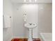 Bathroom with white pedestal sink, tile details, and terracotta tiled floors at 4830 Estrada De Costa, Sarasota, FL 34242