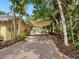 Exterior view of home with gravel driveway and mature landscaping at 4830 Estrada De Costa, Sarasota, FL 34242