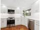 Updated kitchen with stainless steel appliances, modern white cabinets, and tile flooring at 4830 Estrada De Costa, Sarasota, FL 34242