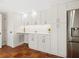Kitchen with white cabinetry, countertop, refrigerator, and terracotta tile flooring at 4830 Estrada De Costa, Sarasota, FL 34242