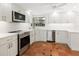 Bright kitchen with stainless steel appliances, white cabinets, and terracotta tile flooring at 4830 Estrada De Costa, Sarasota, FL 34242