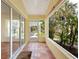 Enclosed patio with tile floors leads to a landscaped backyard, offering a seamless indoor-outdoor living experience at 4830 Estrada De Costa, Sarasota, FL 34242