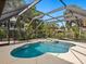 Screened-in pool and hot tub with views of lush greenery and the adjacent lake at 4830 Estrada De Costa, Sarasota, FL 34242