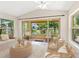 Inviting sun room with comfortable seating, scenic pond views, and access to an outdoor patio at 4830 Estrada De Costa, Sarasota, FL 34242