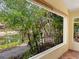 Relaxing view of a tranquil pond framed by tropical greenery from the enclosed porch, blending nature and comfort at 4830 Estrada De Costa, Sarasota, FL 34242