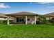 Inviting covered patio with outdoor seating, perfect for enjoying the serene backyard and tropical landscaping at 4869 Antrim Dr, Sarasota, FL 34240