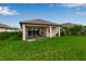 Landscaped backyard featuring a covered patio and lush green lawn, ideal for relaxation and outdoor entertainment at 4869 Antrim Dr, Sarasota, FL 34240