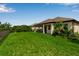 Expansive backyard with covered patio, lush green grass and tropical landscaping at 4869 Antrim Dr, Sarasota, FL 34240