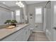 Bathroom features a stone countertop, white cabinets, framed mirror, and plantation shutters at 4869 Antrim Dr, Sarasota, FL 34240