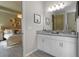 Bright bathroom featuring double sink vanity, framed art, and access to the main bedroom at 4869 Antrim Dr, Sarasota, FL 34240